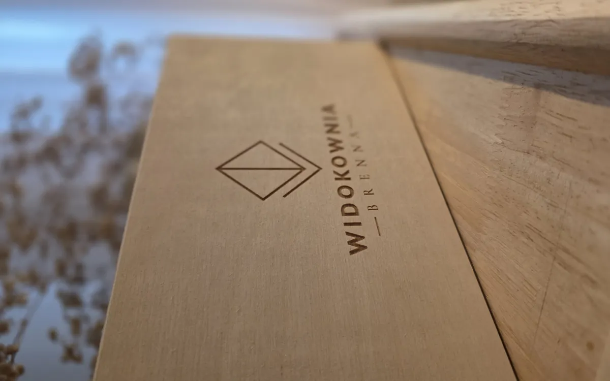 Detail vygravírovaného loga Widokownia na víku krabičky